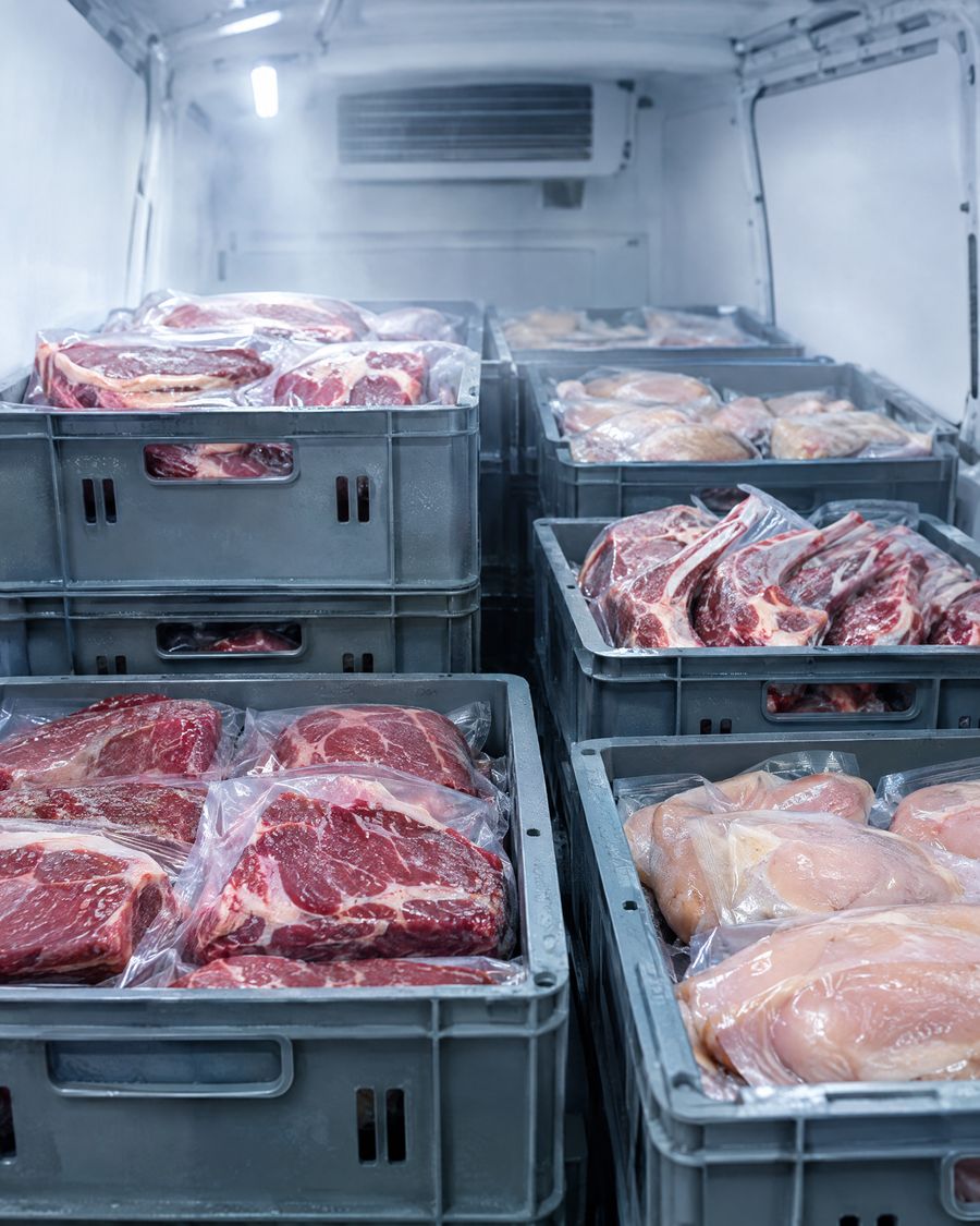 Vacuum-packed beef, lamb and chicken in food-grade crates inside a refrigerated van